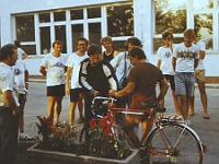 EBI 1988 Sir 028  Úterý 5. 7. 1988 Michalovce. Uprostřed u kola Luboš Glac a dva členové TV štábu. Zleva Otto Pósa, v brýlích člen TV štábu, Zdeněk Zdeněk, Karel Bejček, Dalimila Hlávková, Michal Stánec, Jiří Skála, úplně vpravo Jiří Neuman